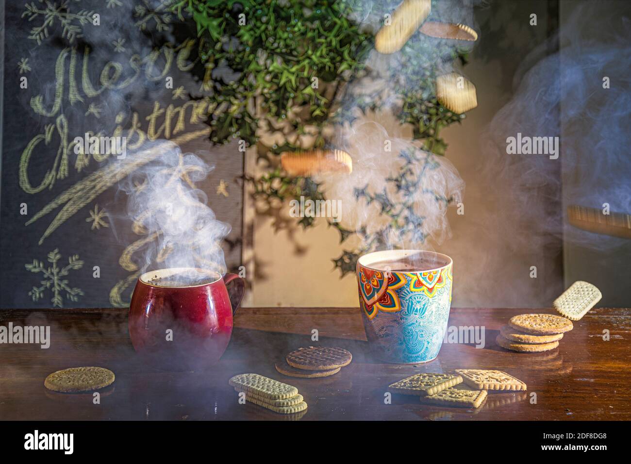 Christmas rustic table with steaming cups of tea, cookies and decorations Stock Photo