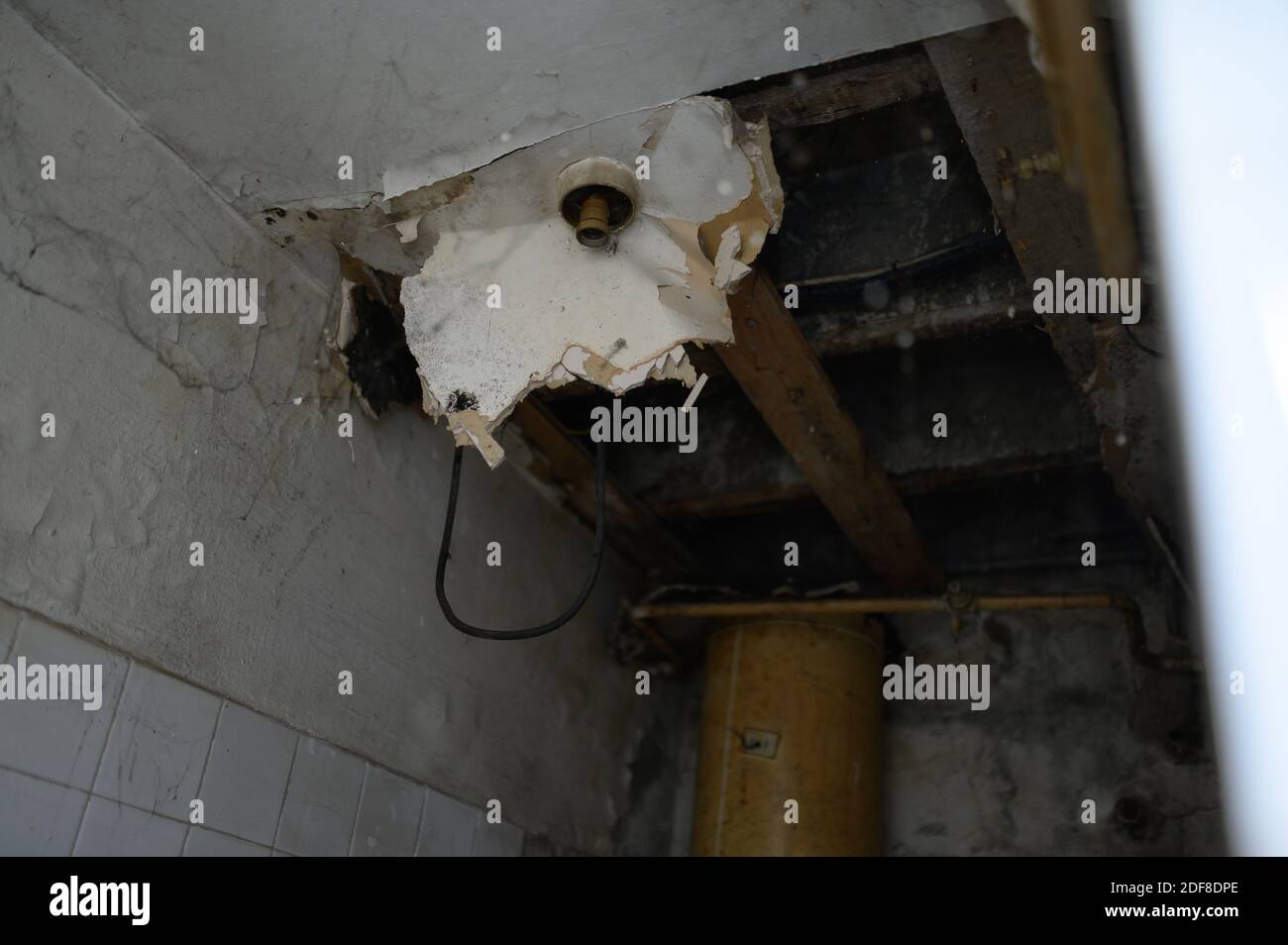 A closeup of a dilapidated ceiling of a comfort room in an abandoned building Stock Photo