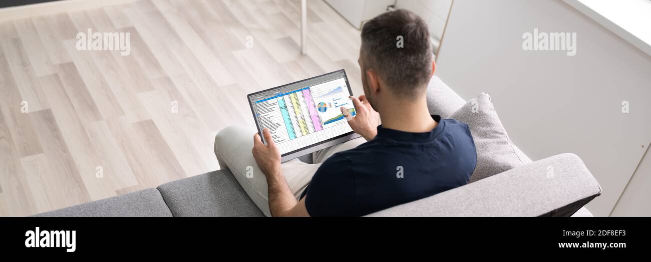 Man Using Spreadsheet Data On Tablet Computer Stock Photo