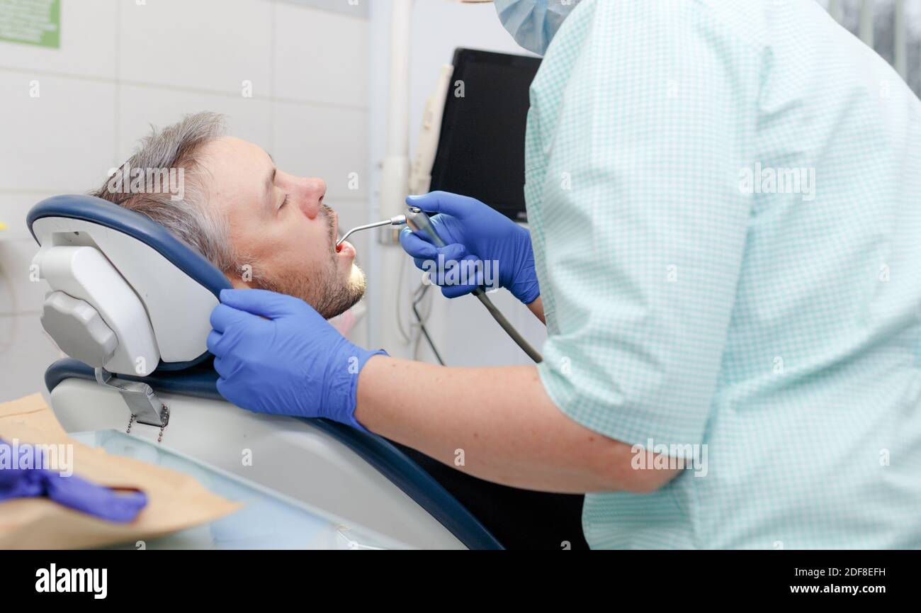 the dentist treats the patient's sick teeth Stock Photo Alamy