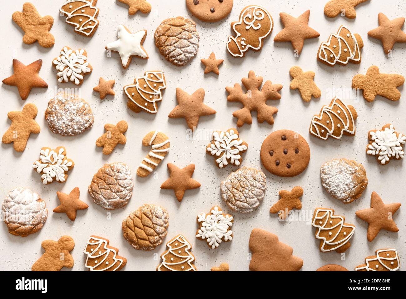 Pattern of different Christmas homemade gingerbread cookies as snowflakes, stars, christmas tree on white background. Xmas abstract background. Stock Photo