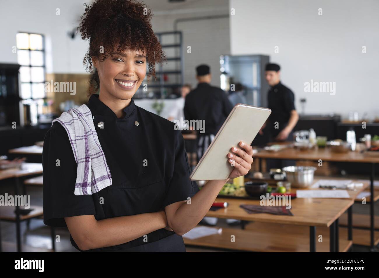 Mixed race female chef in kitchen Stock Photo