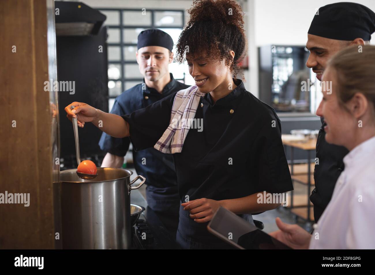 Female chef and divserse group in kitchen Stock Photo