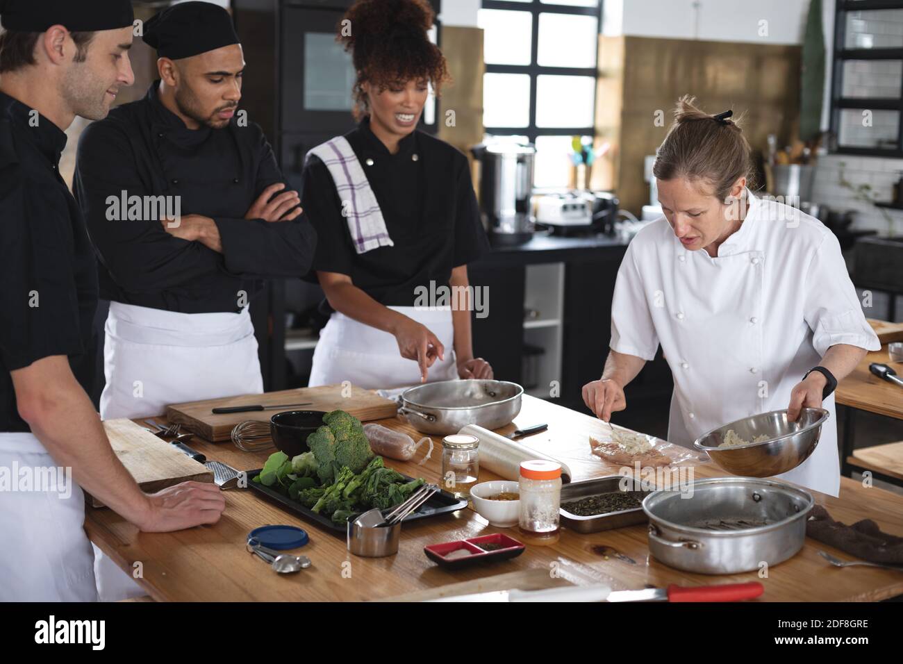 Female chef and divserse group in kitchen Stock Photo