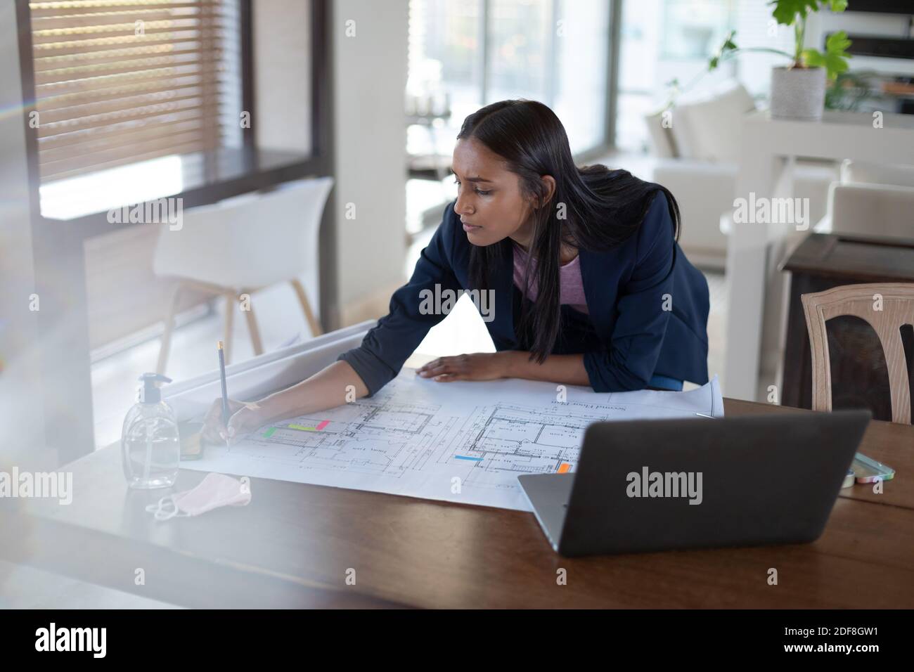 Mixed race woman standing by a table at home Stock Photo