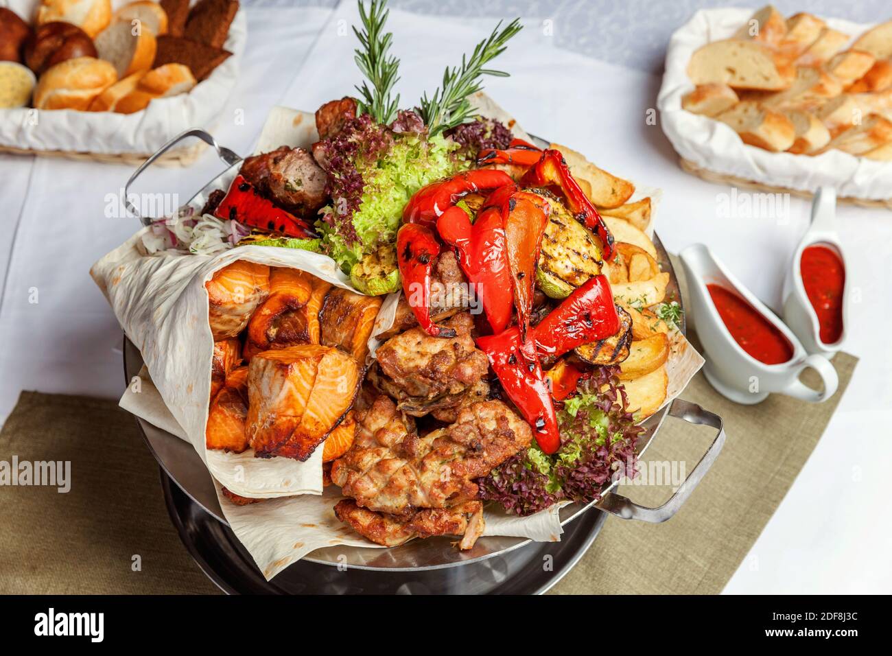 Mixed grill meat, fried vegetables and grilled salmon fish fillets  decoration in warm dish. Assorted delicious grilled kebab served with herbs  on platter. Restaurant menu plate Stock Photo - Alamy