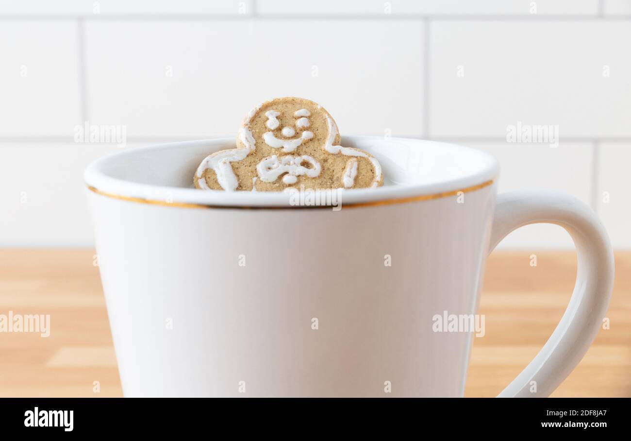 Christmas Holiday Gingerbread Man Cookie Sitting In Mug With Milk On Dark Slate Background Stock Photo