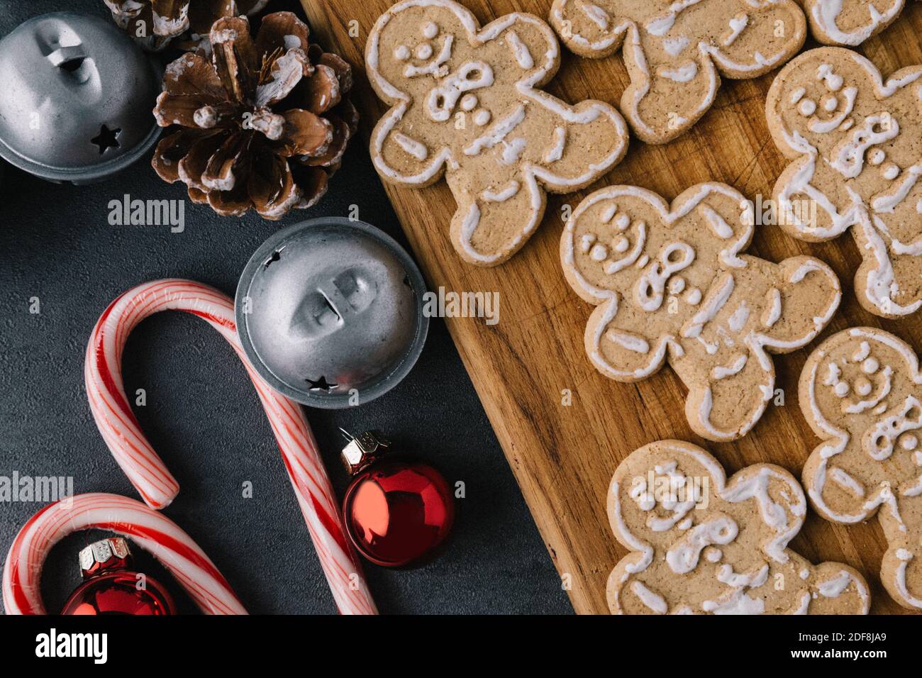 Christmas Gingerbread Man Cookies on Wooden Board With Candy Canes On Dark Slate Texture Stock Photo