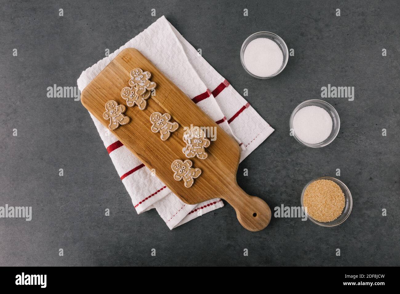 Christmas Gingerbread Man Cookies on Wooden Board With Ingredients On Dark Slate Texture Stock Photo