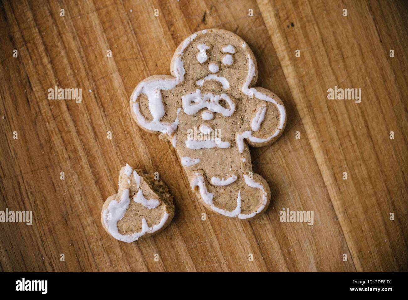 Broken Christmas Gingerbread Man Cookie On Wooden Board Stock Photo