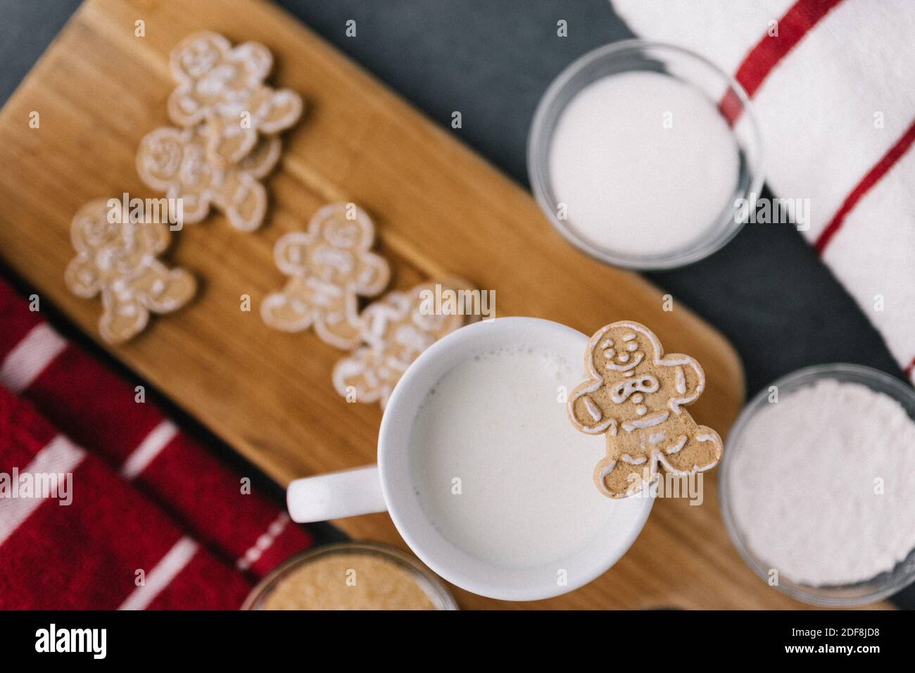 Christmas Holiday Ginger Bread Man Cookie On Mug Of Milk With Cookies And Baking Material Stock Photo