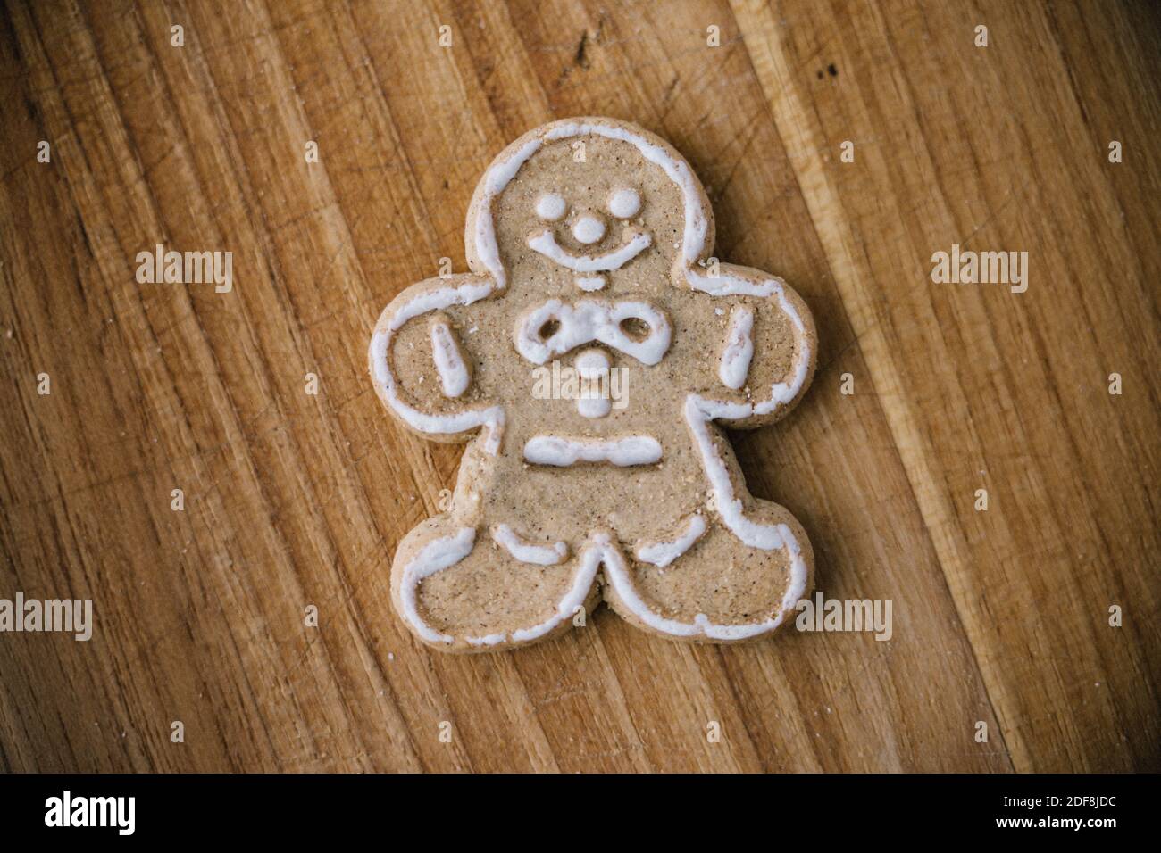 Single gingerbread man cookie on wooden cookie board Stock Photo