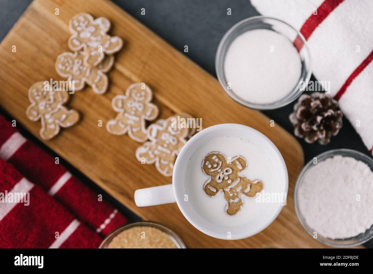 Christmas Holiday Ginger Bread Man Cookie Floating In Mug Of Milk With Cookies And Baking Material Stock Photo