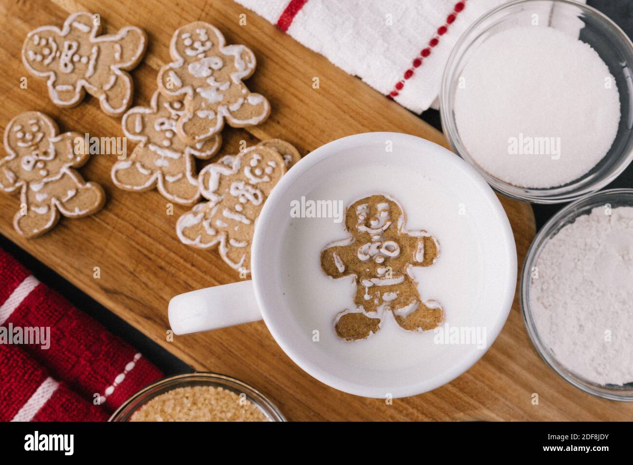 Christmas Holiday Ginger Bread Man Cookie Floating In Mug Of Milk With Cookies And Baking Material Stock Photo