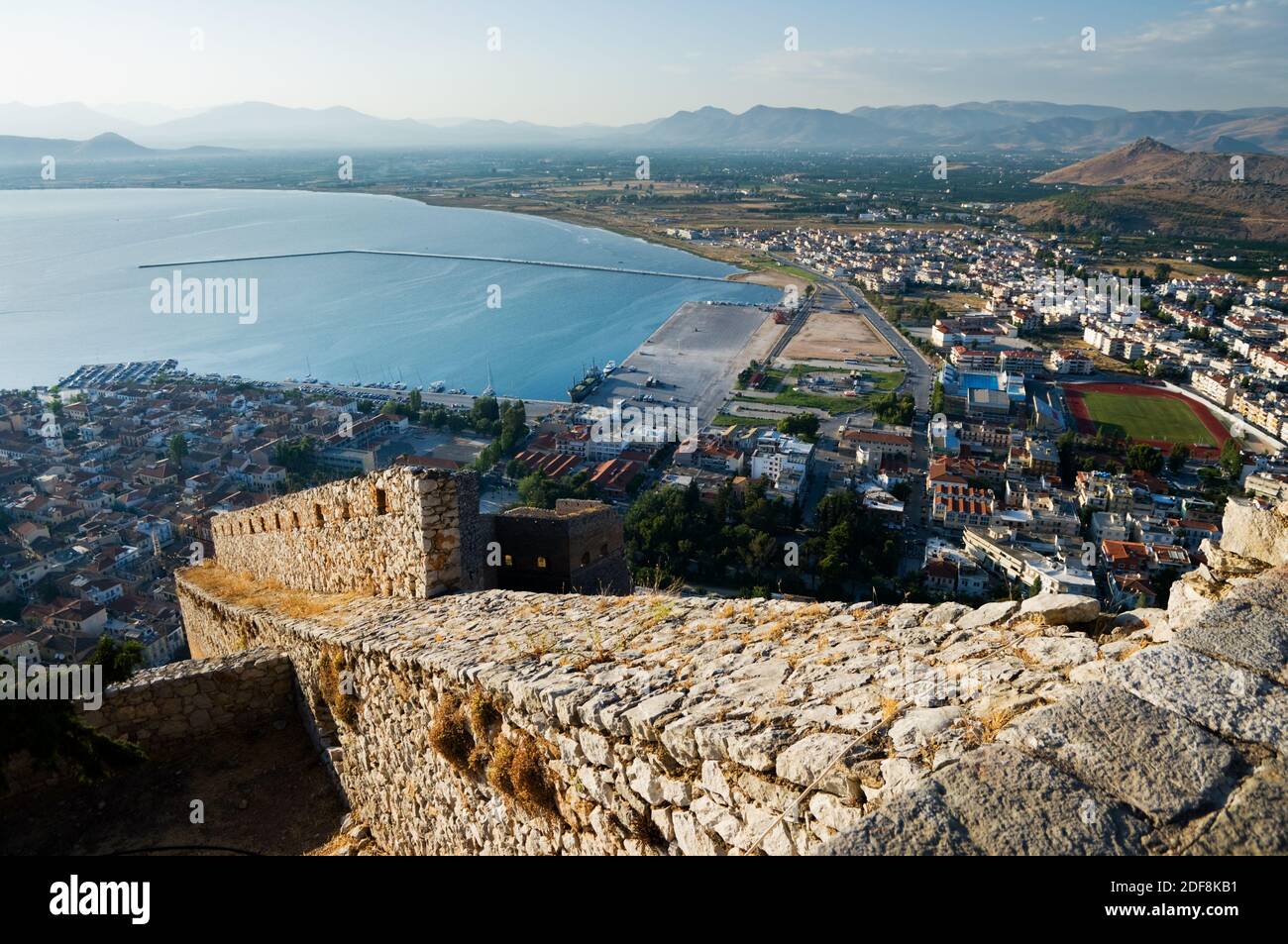 The imposing walls of castle Palamidi, in background the bay and the village of Nafplion, Greece Stock Photo