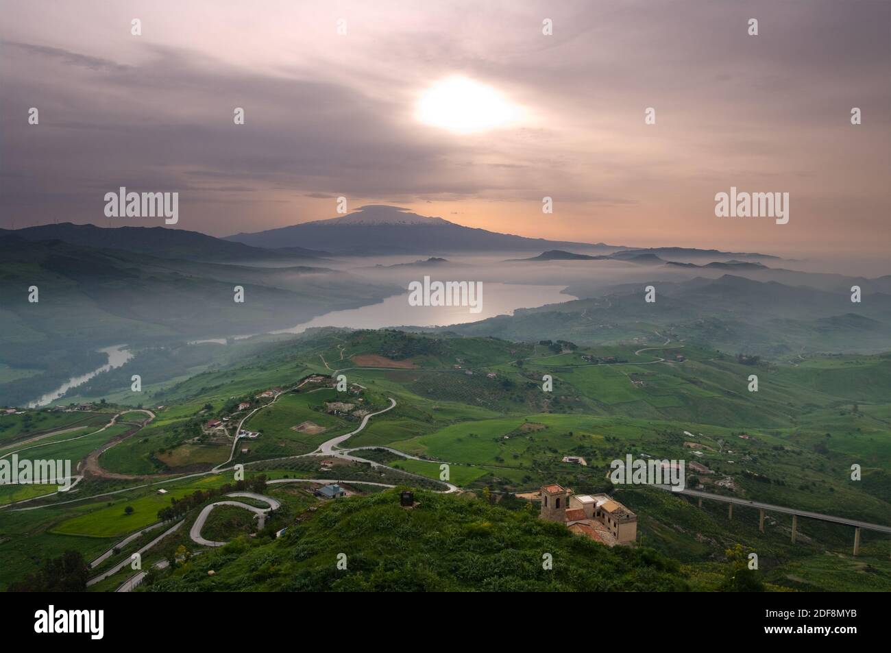 aerial view of countryside in dawn mist on the lake and on the background mount Etna. The picture was taken from Agira, Sicily Stock Photo