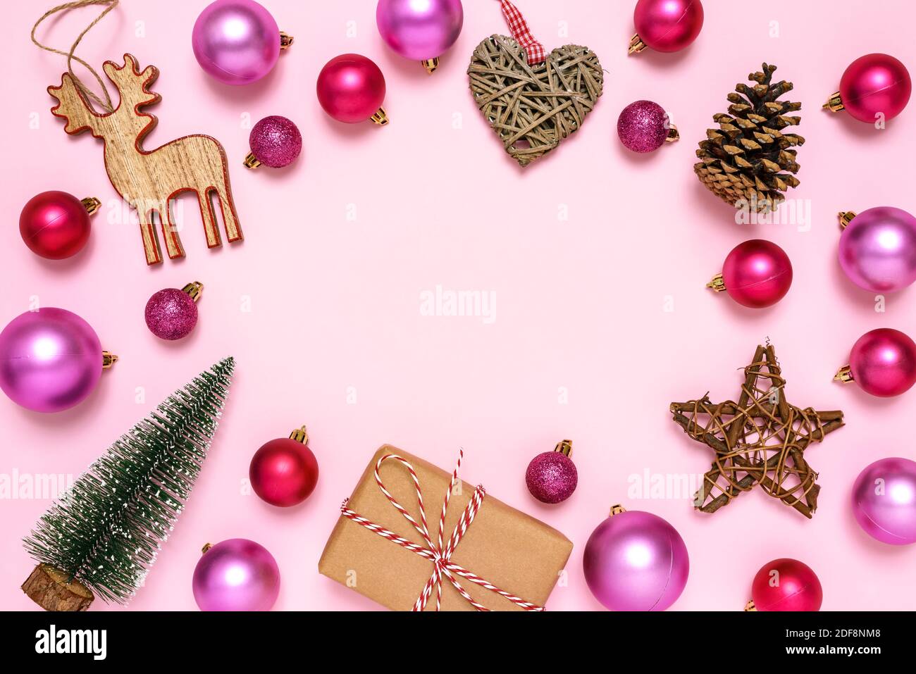 Christmas frame made Christmas ornaments and gift boxes on pastel pink ...