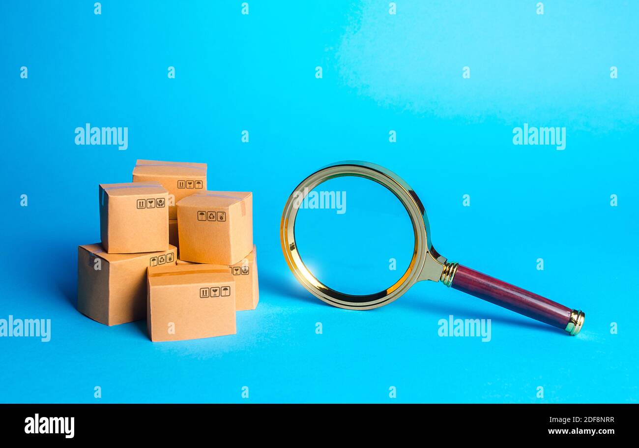 Pile of boxes and magnifying glass. Procurement audit. Monitoring and