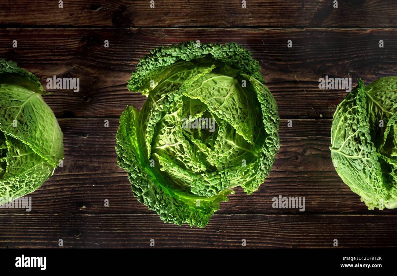 Green savoy cabbage lettuce heads on dark wooden board, view from above Stock Photo Alamy