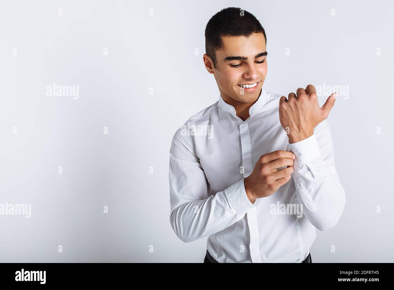 Stylish guy buttoning a button in Studio isolated background Stock ...