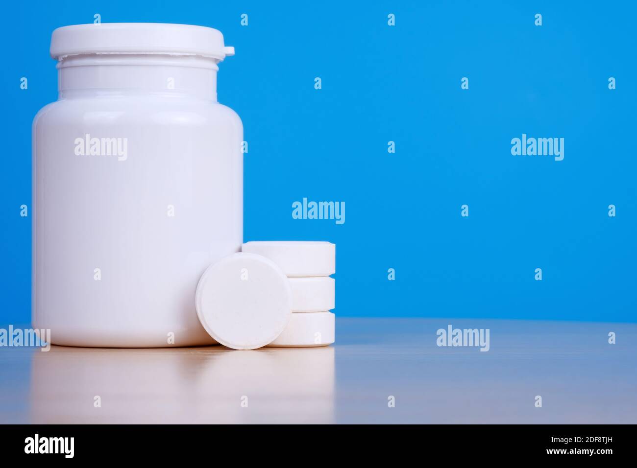Big white tablets and medicine bottle on blue background.  Stock Photo