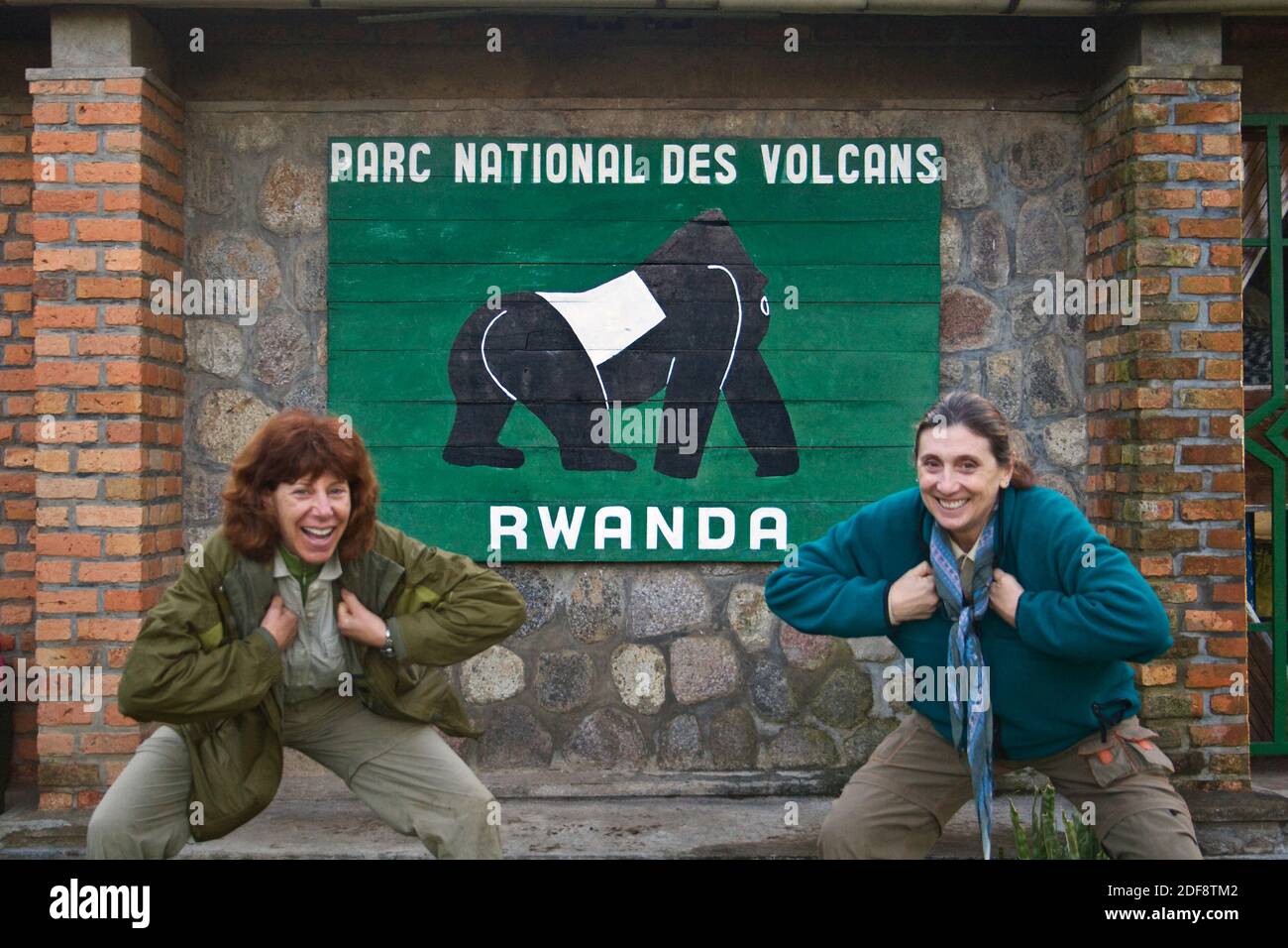 VISITORS clown around in front of the sign to VOLCANOES NATIONAL PARK - RWANDA, AFRICA Stock Photo
