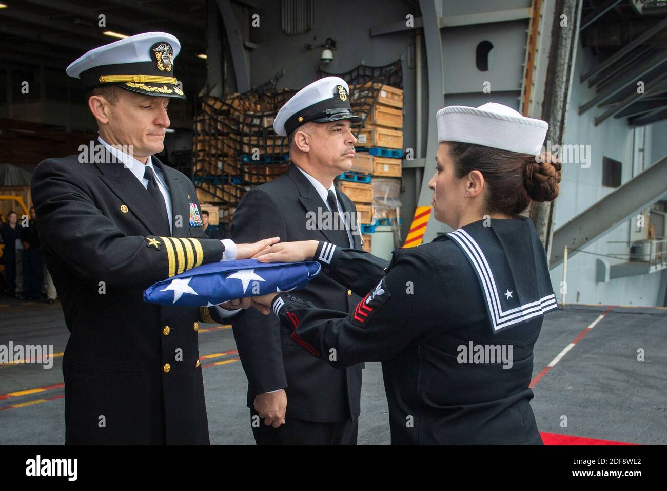 Handout file photo dated January 20, 2020 of Capt. Brett Crozier, left, commanding officer of the aircraft carrier USS Theodore Roosevelt (CVN 71), receives the national ensign in the Pacific Ocean. Brett Crozier, captain of nuclear aircraft carrier Theodore Roosevelt, with more than 100 sailors infected with the coronavirus pleaded Monday with U.S. Navy officials for resources to allow isolation of his entire crew and avoid possible deaths in a situation he described as quickly deteriorating. Photo by US Navy via ABACAPRESS.COM Stock Photo