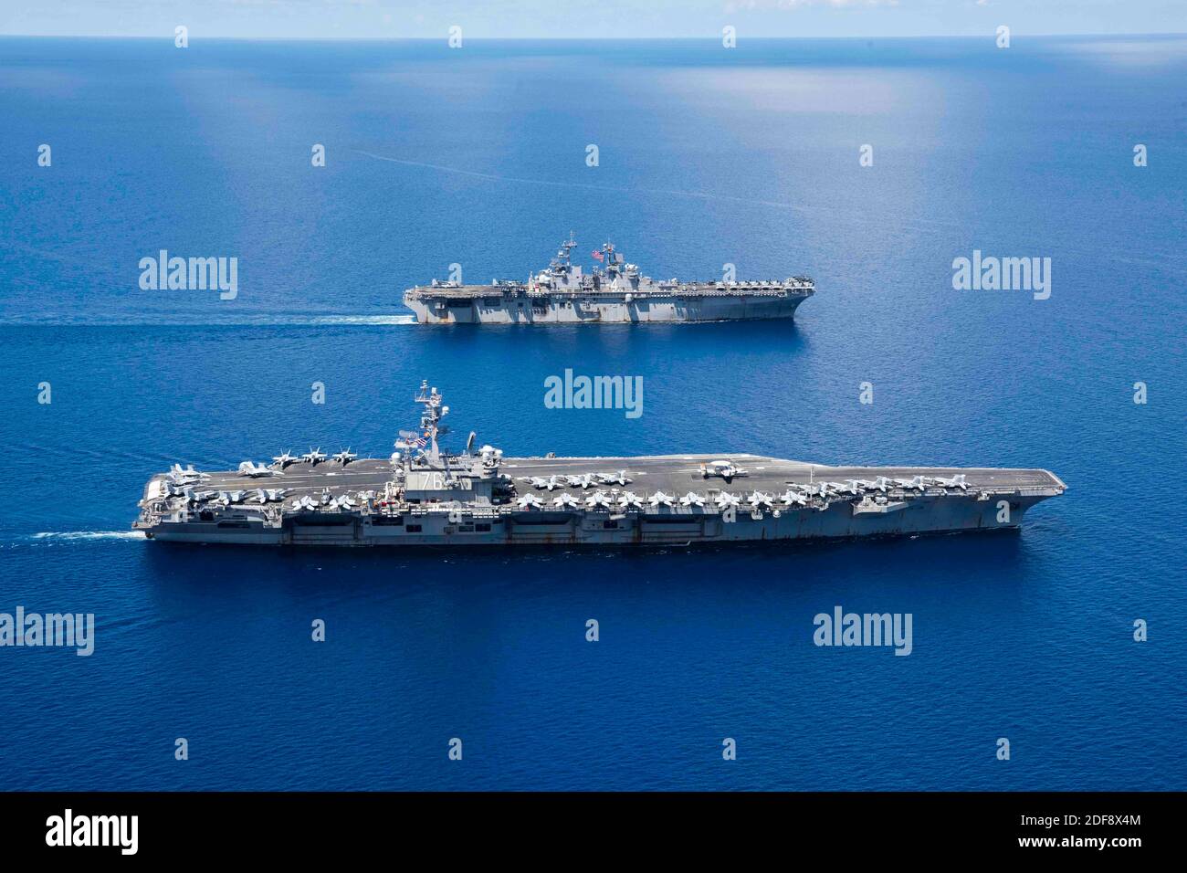 Hand out file photo dated October 6, 2019) of the aircraft carrier USS Ronald Reagan (CVN 76) and the amphibious assault ship USS Boxer (LHD 4) are underway in formation while conducting security and stability operations in the U.S. 7th Fleet area of operations in South China Sea. An unknown number of sailors onboard the Nimitz class aircraft carrier USS Ronald Reagan, which forward-deployed in Japan and presently pier-side there, have tested positive for the COVID-19 novel coronavirus. This comes just a day after the U.S. Navy announced it had quarantined the entire crew of another aircraft c Stock Photo