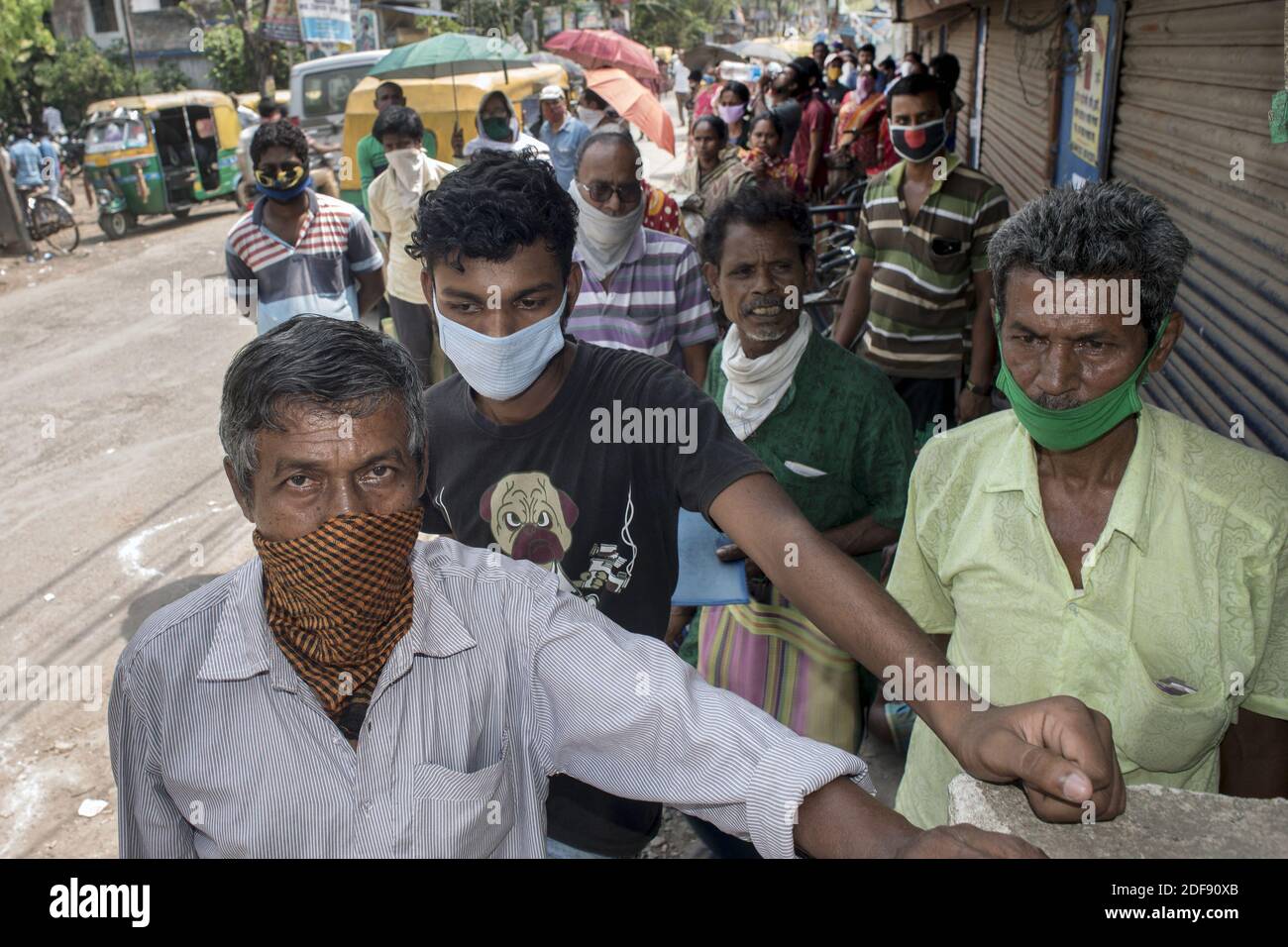 Indian people queue up for ration at a government controlled shop in ...