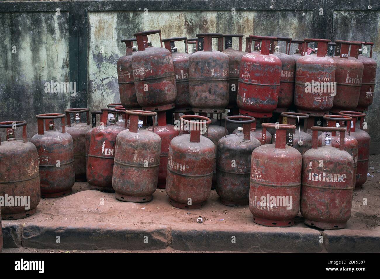 Cooking gas cylinders are stacked on a footpath before being despatched ...