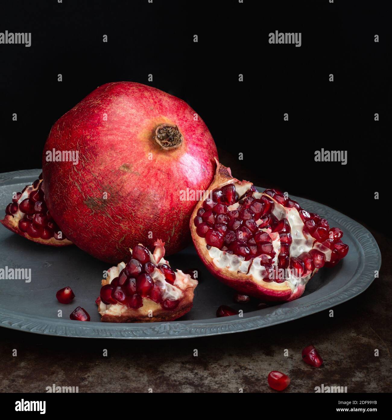 Pomegranate Fruit Whole And Open On A Silver Platter And Black Background Square Stock Photo Alamy