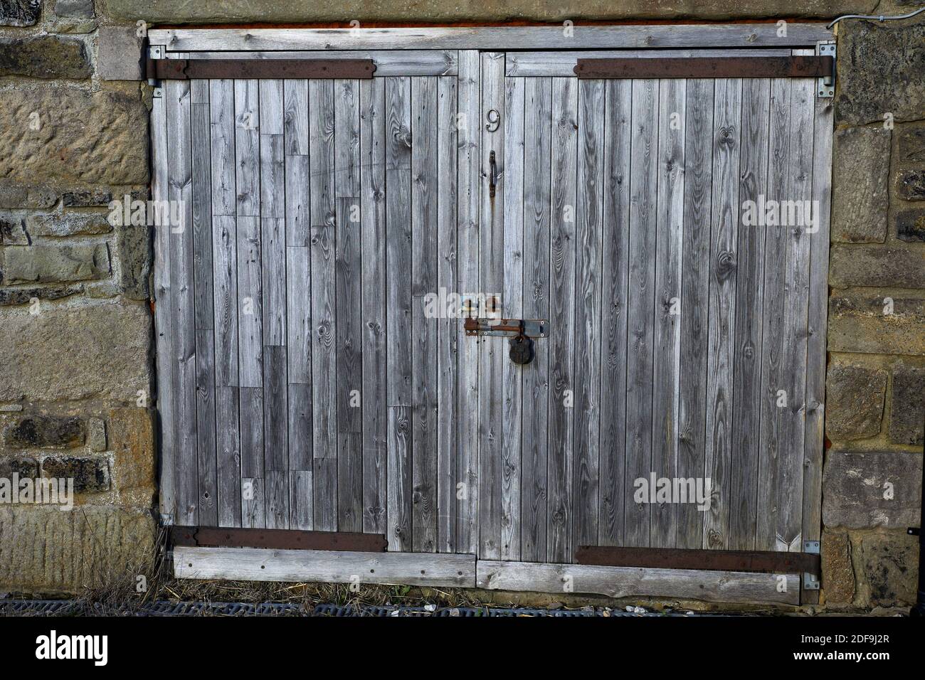 Wooden barn doors hanging on farm building Stock Photo