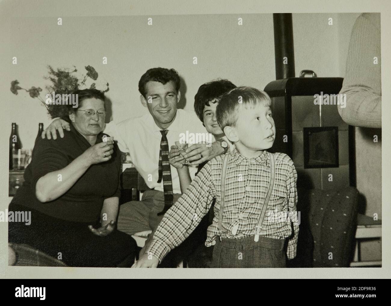 Historical Photo:  Family members 4.4.1961 in the living room with an old oven, celebrating engagement. Reproduction in Marktoberdorf, Germany, October 26, 2020.  © Peter Schatz / Alamy Stock Photos Stock Photo