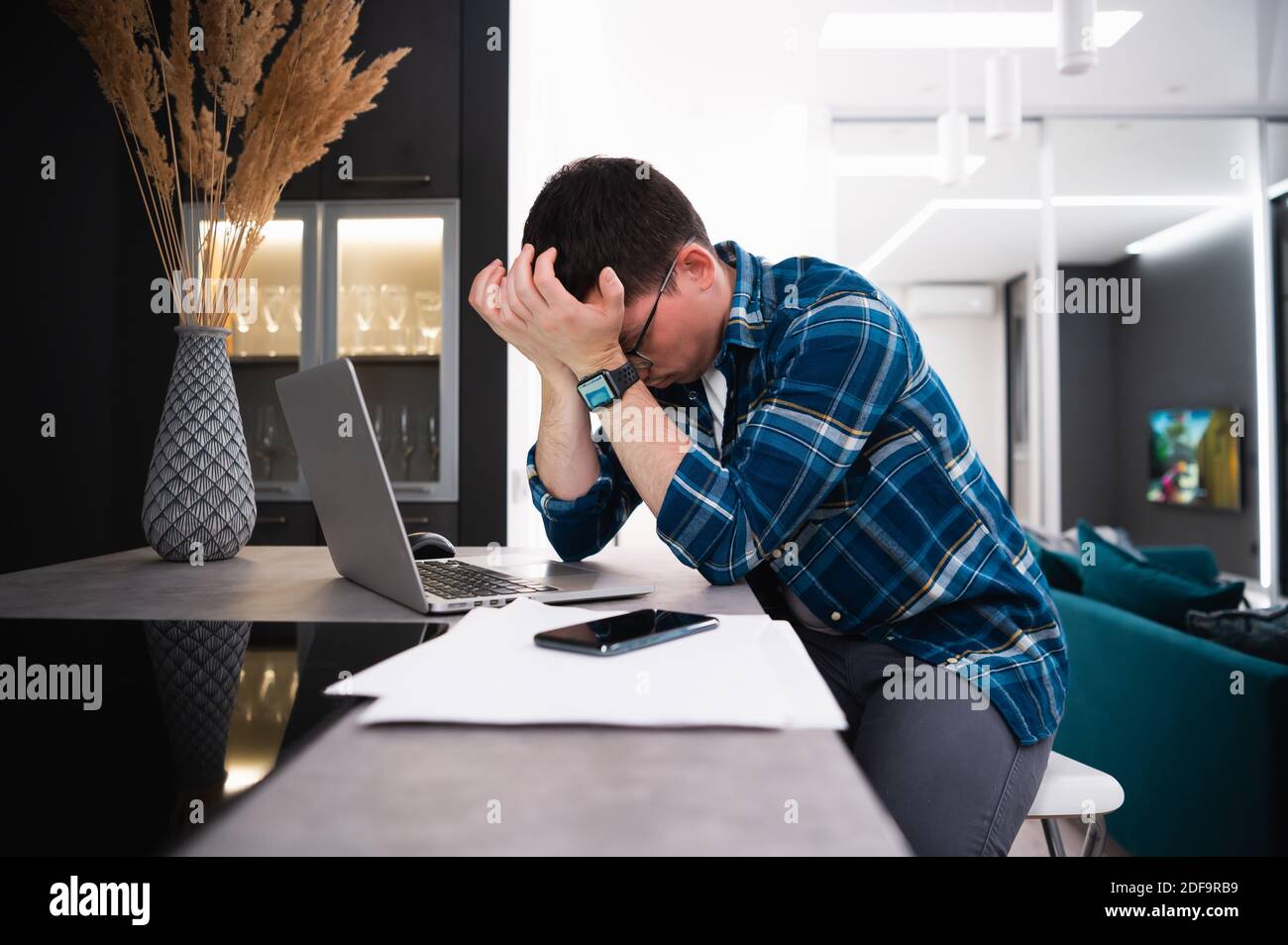 Sleepy exhausted man working at home with laptop, sleep deprivation and