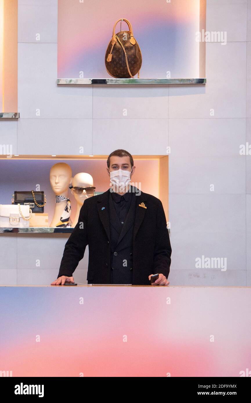 Louis Vuitton staff wearing protective masks work in the Louis