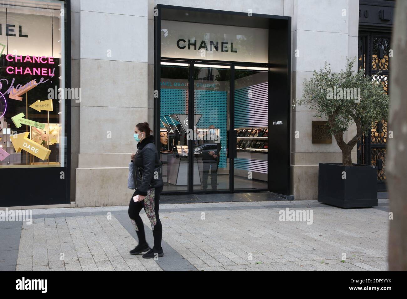 Customers wearing protective face masks strolling close from Chanel store  on the Champs Elysee avenue on May 11, 2020 in Paris, France. France began  a gradual easing of its lockdown measures and