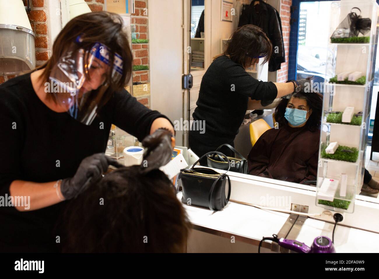 hairdresser wears a visor for protection against the coronavirus work