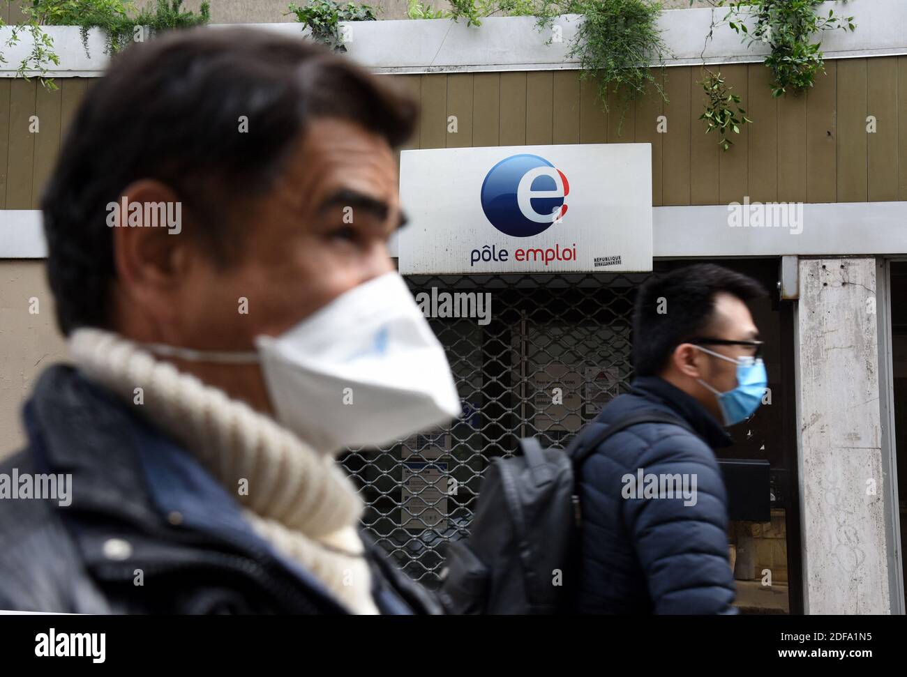 People wearing protective masks pass by a Pole Emploi (job center) on May 12, 2020 in Paris, France. Ten million workers in France are currently on a temporary unemployment scheme designed to avoid mass redundancies as companies struggle to stay afloat during the coronavirus pandemic. As Covid-19 hit France, the government quickly introduced a system whereby companies can temporarily put staff on reduced or no hours while the state picks up all or most of their net wages for unworked time.Photo by Alain Apaydin/ABACAPRESS.COM Stock Photo