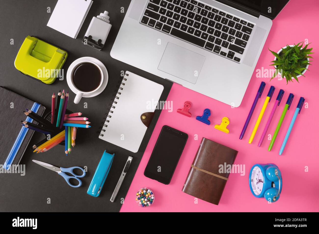 Office supply items, laptop and coffee on black and pink background.  Colorful and vibrant office table still life Stock Photo - Alamy