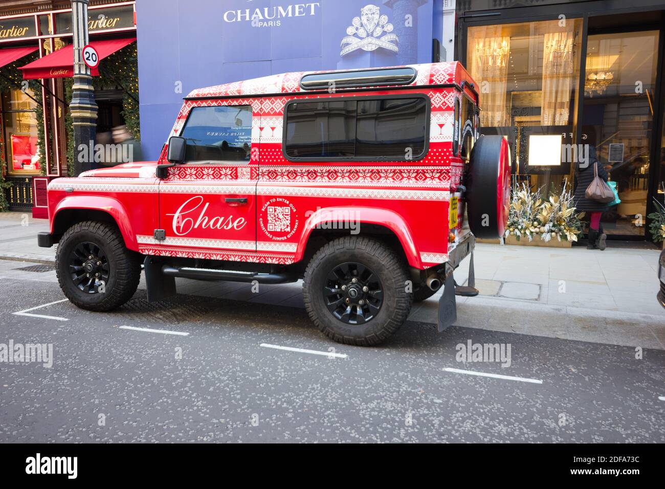 Chase jeep parked outside Chaumet store on bond street London west end with its owner picking up Christmas orders by the store entrance, England Stock Photo