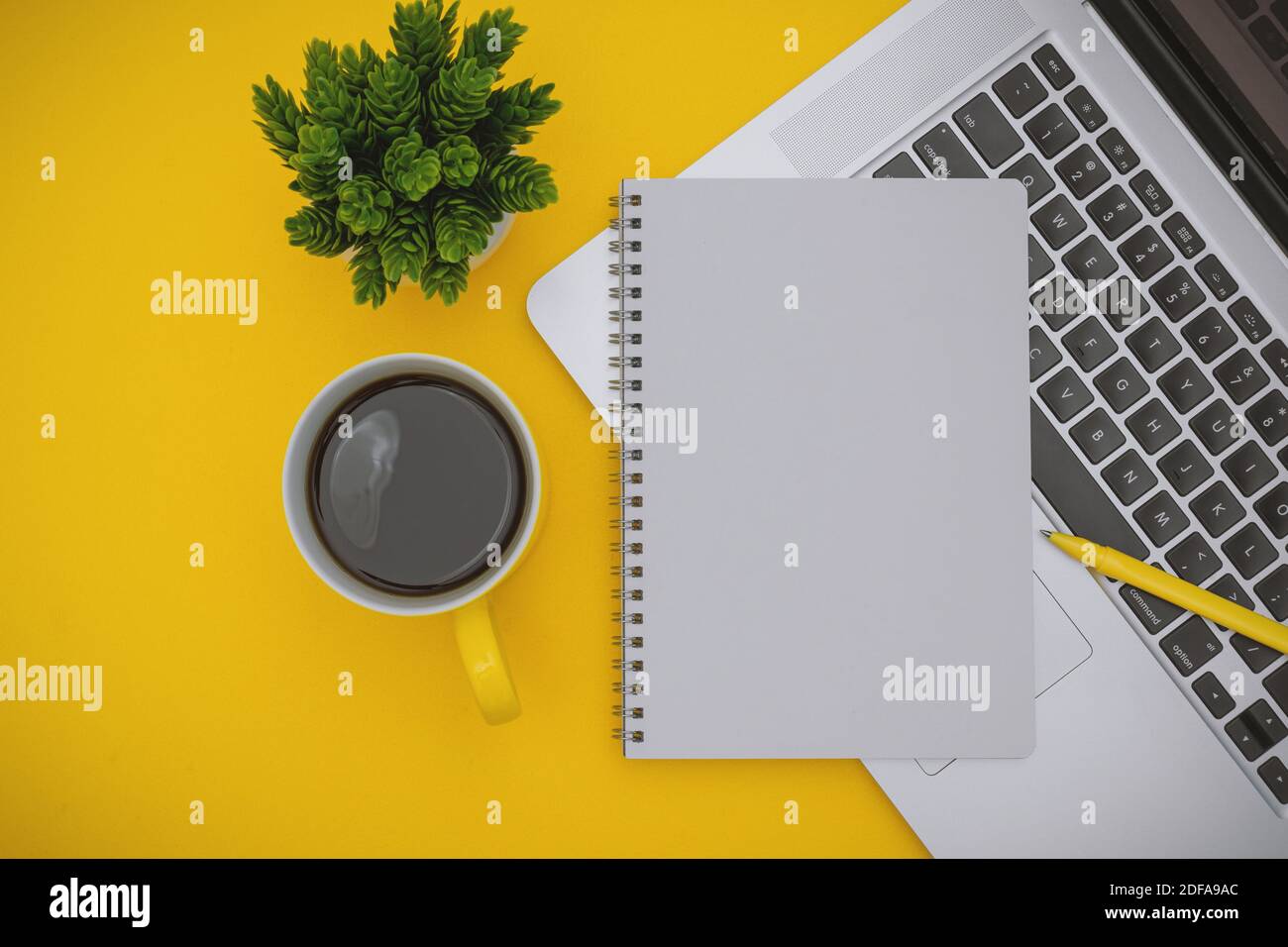 Overhead View of Notepad and Laptop on Yellow Background Stock Photo ...