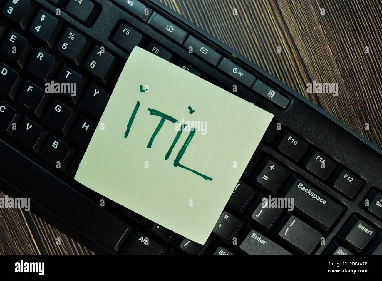ITIL write on sticky notes isolated on Wooden Table. Stock Photo