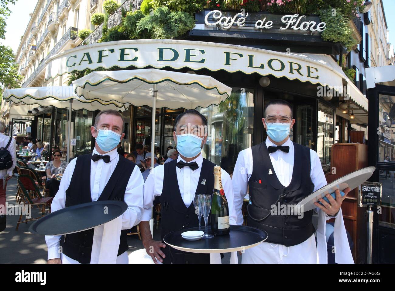 3 waiters pose with masks in front of world famous Parisian  Café-Restaurant, Café de Flore as restaurants, cafés and bars are allowed  to reopen on Tuesday June 2 in all departments, but