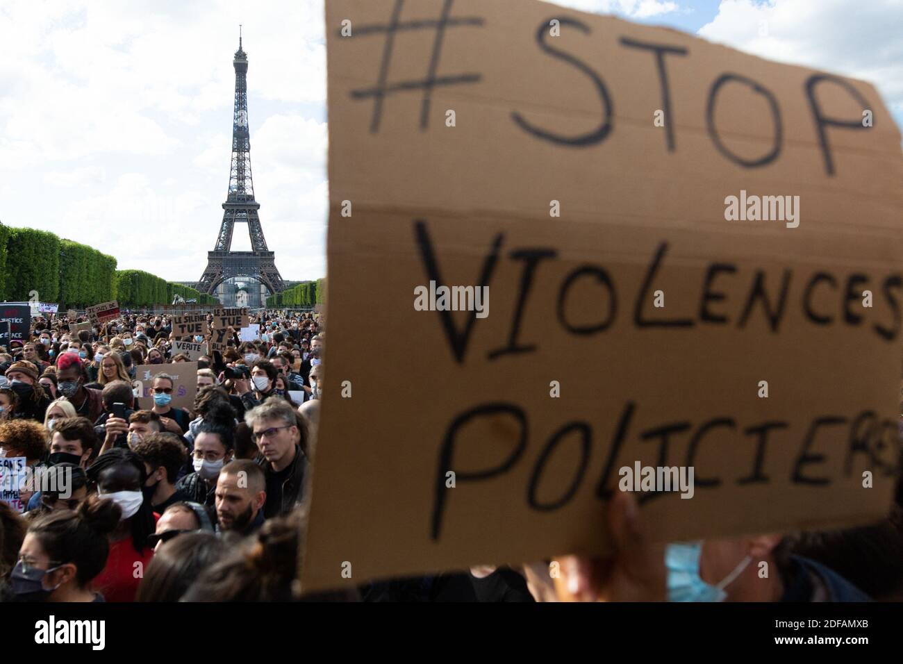 A protester raise fists and holds banner stop police violence on Champ de Mars, in Paris on June 6, 2020, as part of 'Black Lives Matter' worldwide protests against racism and police brutality in the wake of the death of George Floyd, an unarmed black man killed while apprehended by police in Minneapolis, US. Police banned the rally as well as a similar second one on the Champ de Mars park facing the Eiffel Tower today, saying the events were organised via social networks without official notice or consultation. But on June 2, another banned rally in Paris drew more than 20000 people in suppor Stock Photo