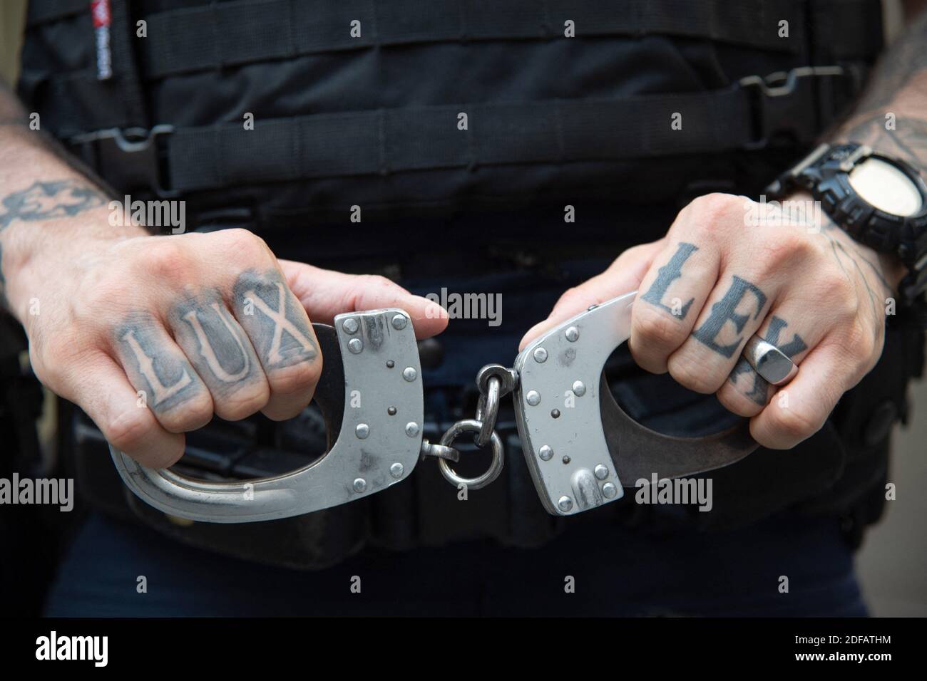 Police officers demonstrate by putting their handcuffs on the ground at
