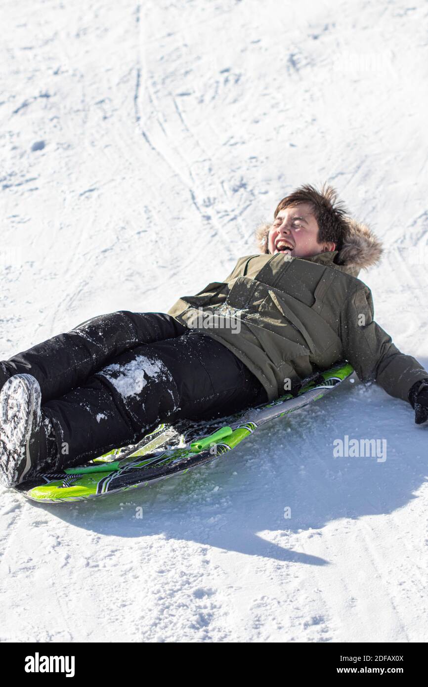 Little Boy Sledding in the Snow Stock Photo