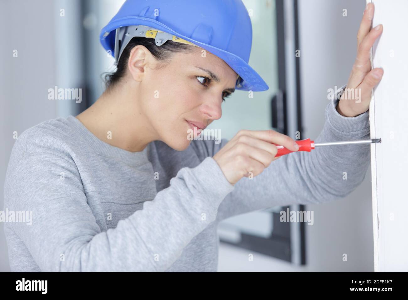 a female worker is screwing the wall Stock Photo - Alamy