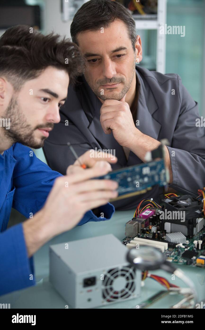 two handsome engineers working on electronics components Stock Photo