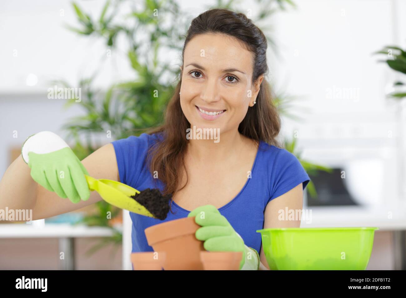 happy young woman potting plants Stock Photo Alamy
