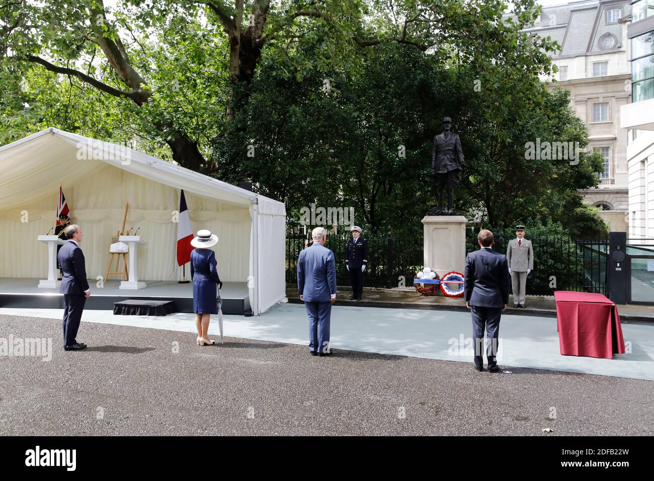 Britain's Foreign Secretary Dominic Raab (L), Britain's Camilla, Duchess of Cornwall (2L), Britain's Prince Charles, Prince of Wales (3L) and French President Emmanuel Macron (R) pause during a wreath-laying ceremony at Carlton Gardens in central London on June 18, 2020 at the statue of former French president Charles de Gaulle to mark the 80th anniversary of De Gaulle's appeal to French people to resist the Nazi occupation. - Macron visited London on June 18 to commemorate the 80th anniversary of former French president Charles de Gaulle's appeal to French people to resist the Nazi occupation Stock Photo